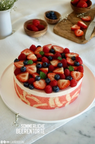 Fruchtige Sahnetorte mit Erdbeermousse, Dekorbiskuit und ganz vielen süßen Beeren.